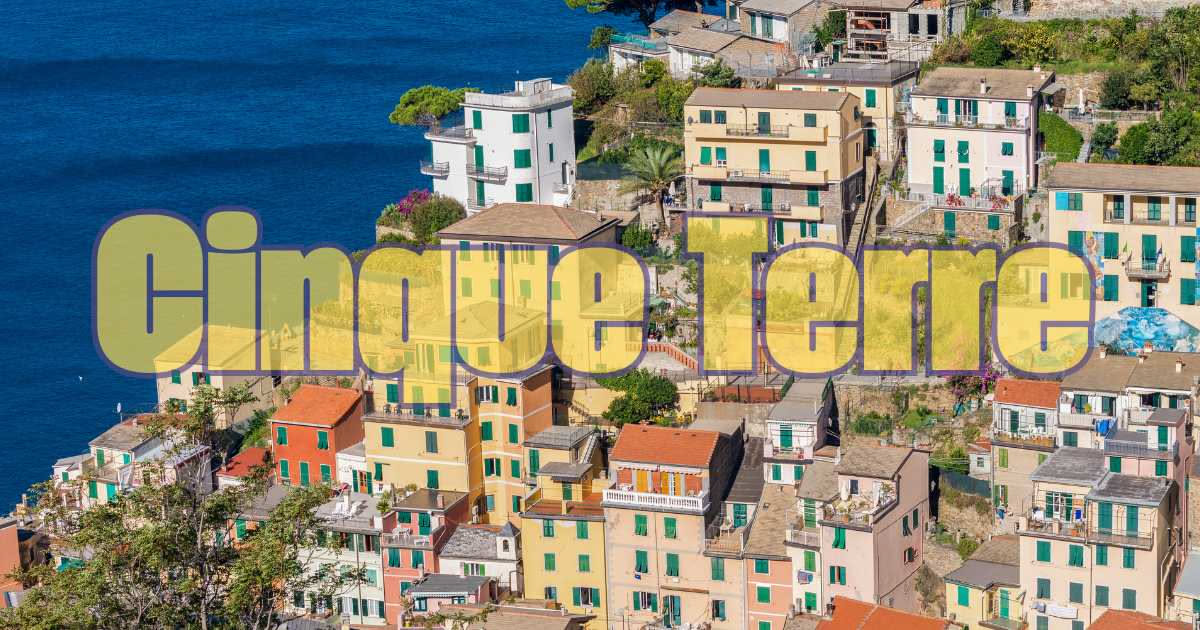 Persona seduta a un tavolo con vista su Vernazza e Monterosso, guarda lo schermo di un computer portatile mentre studia mappe del territorio e informazioni turistiche